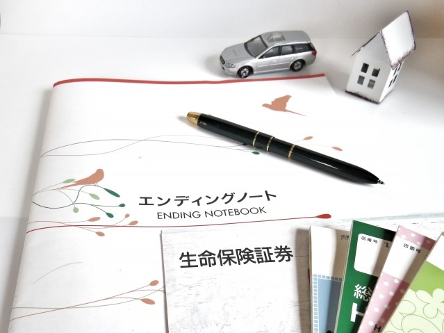 エンディングノートと通帳とペンと家と車の模型