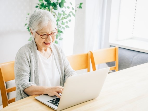 パソコンで検索をかける高齢者女性
