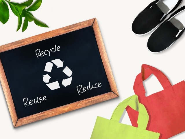 黒板に書かれたRecycleとReuseとReduceの文字とエコバッグと靴