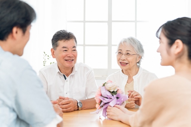 笑顔で話す高齢者夫婦と家族